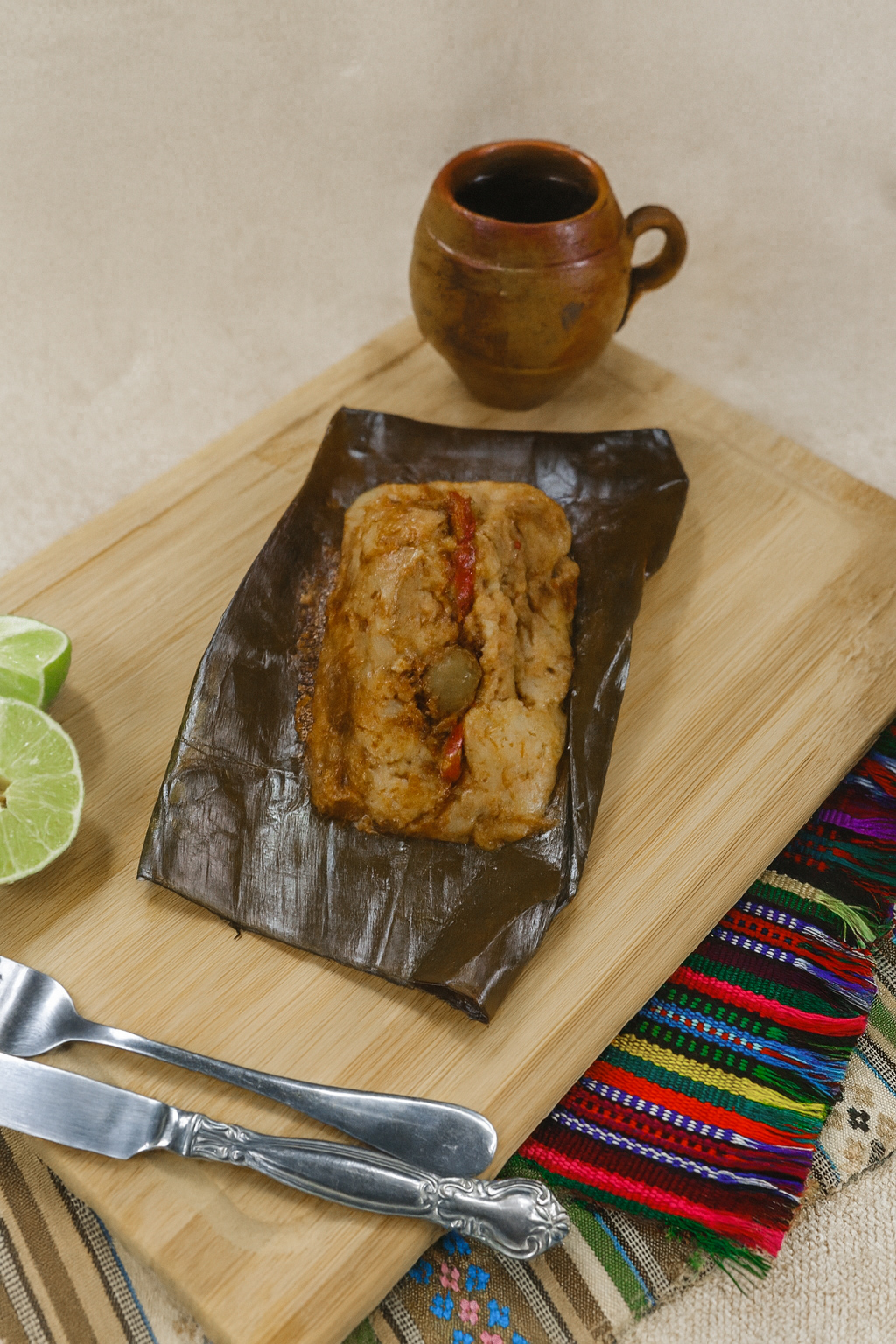 Tamal guatemalteco servido en una tabla de madera con servilleta tipica